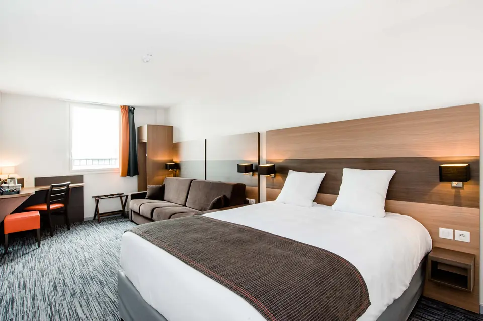 Chambre spacieuse avec grand lit et canapé