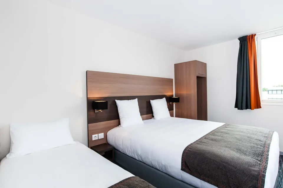 Chambre triple avec un grand lit et un lit simple