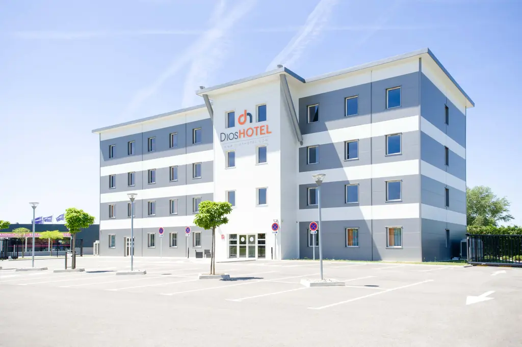 Façade du Dios Hotel Toulouse Nord à Bruguières sous un ciel bleu